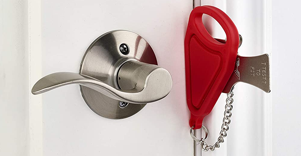 Portable travel door lock installed on a hotel room door